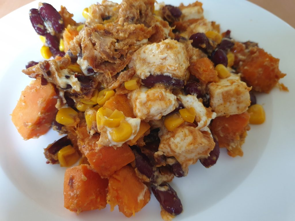 Süßkartoffelpfanne mit Feta, Datteln, Kidneybohnen und Mais, gewürzt mit Zimt, Cayennepfeffer und Salz.